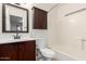 This cozy bathroom has a shower over bath, a dark wood vanity and a wall cabinet at 501 W Hononegh Dr # 2, Phoenix, AZ 85027