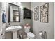 This powder room features a pedestal sink, a large mirror, and decorative wall art at 5054 S Advant Ter, Mesa, AZ 85212