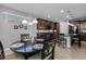 Bright dining area near a kitchen island, featuring large windows and modern lighting at 5054 S Advant Ter, Mesa, AZ 85212