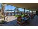 Charming covered outdoor lounge with comfortable seating, lush landscaping, and a view of the pool at 5054 S Advant Ter, Mesa, AZ 85212
