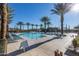 Beautiful community pool with palm trees, lounge chairs, and a clear blue sky at 5054 S Advant Ter, Mesa, AZ 85212