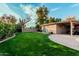 Expansive backyard features lush lawn, covered patio, and block fencing offering privacy at 5641 E Aster Dr, Scottsdale, AZ 85254