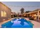 Lush backyard showcasing a refreshing pool, outdoor seating, ambient lighting, and an ideal outdoor living space at 5641 E Aster Dr, Scottsdale, AZ 85254