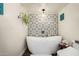 Freestanding tub with decorative tile backsplash and modern fixtures at 5641 E Aster Dr, Scottsdale, AZ 85254