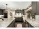 Stylish gray kitchen featuring granite countertops, a farmhouse sink, and modern lighting fixtures at 5641 E Aster Dr, Scottsdale, AZ 85254