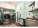 Functional laundry room featuring stainless steel washer and dryer, ample storage, and a convenient folding area at 5641 E Aster Dr, Scottsdale, AZ 85254