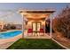Charming outdoor space with a pergola, seating area, and well-manicured lawn by the sparkling pool at 5641 E Aster Dr, Scottsdale, AZ 85254