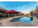 Inviting pool area with poolside bar, umbrella, and string lights perfect for a summer day at 5641 E Aster Dr, Scottsdale, AZ 85254