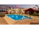 Beautiful in-ground pool surrounded by lush landscaping and highlighted by outdoor seating and string lights at 5641 E Aster Dr, Scottsdale, AZ 85254