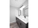 Bathroom showing a white countertop, modern mirror, gray cabinets, and wood flooring at 6254 E Winchcomb Dr, Scottsdale, AZ 85254