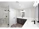 Bright bathroom showcasing marble shower, double sinks, modern lighting and gray cabinets at 6254 E Winchcomb Dr, Scottsdale, AZ 85254