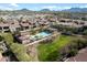Stunning aerial view of the community pool, green space, and surrounding homes, all with a mountain view in the background at 7340 E Conquistadores Dr, Scottsdale, AZ 85255