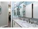 This bathroom features double sinks with granite countertops, mirrors, and white cabinets at 7340 E Conquistadores Dr, Scottsdale, AZ 85255