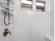 This bathroom features a tiled shower with a shower head, bench seat and two windows at 7340 E Conquistadores Dr, Scottsdale, AZ 85255