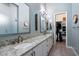 Elegant bathroom featuring double sinks, granite countertops, and a walk-in closet at 7340 E Conquistadores Dr, Scottsdale, AZ 85255