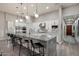Bright, modern kitchen with white cabinets, stainless steel appliances, and a large gray granite island with bar stool seating at 7340 E Conquistadores Dr, Scottsdale, AZ 85255