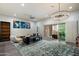 Bright, open-concept living area with stylish decor, ceiling fan, and sliding glass door to the patio at 7340 E Conquistadores Dr, Scottsdale, AZ 85255