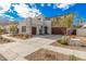 A modern two-story home exhibits a neutral color scheme, multiple garage doors, and desert landscaping at 921 E Buist Ave, Phoenix, AZ 85042