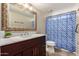 Cozy bathroom with a decorative shower curtain, vanity, and a framed mirror at 926 W Grand Caymen Dr, Gilbert, AZ 85233