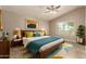 Stylish bedroom with a wood bed frame, colorful pillows, modern art, and tiled floors at 926 W Grand Caymen Dr, Gilbert, AZ 85233