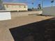 Gravel backyard with a large storage shed and privacy wall at 9840 W Devonshire Dr, Arizona City, AZ 85123