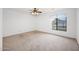 Spacious bedroom featuring neutral carpet, ceiling fan, and bright window at 1079 S Western Skies Dr, Gilbert, AZ 85296
