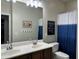 Bathroom features a double vanity and blue and white shower curtain at 10909 E Sentiero Ave, Mesa, AZ 85212