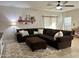 Cozy living room boasts a large sectional sofa, decorative shelf and a plush rug with a unique geometric pattern at 10909 E Sentiero Ave, Mesa, AZ 85212