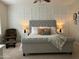 Relaxing main bedroom boasts a neutral color palette, stylish headboard and modern decorative wall paneling at 10909 E Sentiero Ave, Mesa, AZ 85212