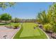 Backyard putting green with lush landscaping, artificial turf, and manicured lawn at 12035 W Roy Rogers Rd, Peoria, AZ 85383