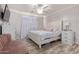 Relaxing bedroom featuring a ceiling fan, wood-look flooring, and a comfortable sitting area at 12333 W Corrine Dr, El Mirage, AZ 85335