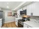 Well-lit kitchen featuring stainless steel appliances, white cabinets, and laminate flooring at 1504 W 6Th St, Mesa, AZ 85201