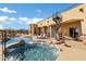 A luxurious pool area features a serene jacuzzi, lounge chairs, and a spiral staircase to the upper deck at 16915 E Desert Vista Trl, Rio Verde, AZ 85263