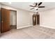 This carpeted bedroom includes a ceiling fan, two doors, and access to a walk-in closet at 18442 N 104Th Ave, Sun City, AZ 85373