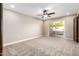 This bedroom offers neutral carpet, a ceiling fan, and sliding glass doors to the patio at 18442 N 104Th Ave, Sun City, AZ 85373
