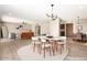 Open-concept floor plan showing dining area with a modern chandelier, hardwood floors, and living area at 18442 N 104Th Ave, Sun City, AZ 85373