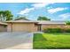 Charming single-story home with well-maintained lawn, mature landscaping, and spacious two-car garage at 18442 N 104Th Ave, Sun City, AZ 85373
