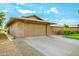 Spacious two-car garage featuring a paved driveway, brick accents, and a well-manicured yard at 18442 N 104Th Ave, Sun City, AZ 85373