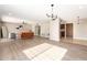 Open-concept floor plan with modern chandelier, hardwood floors, neutral paint, and spacious living area at 18442 N 104Th Ave, Sun City, AZ 85373