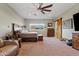 Spacious bedroom featuring a ceiling fan, barn door, seating, and a window with mountain views at 19612 W Georgia Ave, Litchfield Park, AZ 85340