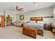 Bright bedroom featuring a wooden bed frame, large windows, beige carpeting, and bonus room space at 19612 W Georgia Ave, Litchfield Park, AZ 85340