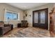 Foyer featuring decorative iron doors, a patterned rug, wood look floors, and a view of the outdoors at 19612 W Georgia Ave, Litchfield Park, AZ 85340