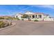 Front exterior showcasing desert landscaping, circular driveway, white stucco and a red tile roof at 19612 W Georgia Ave, Litchfield Park, AZ 85340