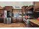 Modern kitchen with stainless steel appliances, dark wood cabinets, granite countertops, and stylish backsplash at 19612 W Georgia Ave, Litchfield Park, AZ 85340