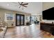 Expansive living room featuring wood-look floors, entertainment center, and a decorative front door at 19612 W Georgia Ave, Litchfield Park, AZ 85340
