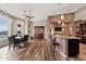 Open living space with kitchen island, dining area, brick accents, and wood-look flooring at 19612 W Georgia Ave, Litchfield Park, AZ 85340