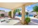 This back patio is covered and has a view of the pool and landscaping at 20218 N 61St Ave, Glendale, AZ 85308