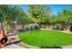 Beautiful backyard featuring lush landscaping, mature trees, and a fire pit at 20218 N 61St Ave, Glendale, AZ 85308