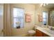 This bathroom has a window, vanity with a white countertop, and white toilet at 20218 N 61St Ave, Glendale, AZ 85308