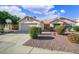 Inviting single-story home with a two-car garage, landscaped front yard, and mature trees, exhibiting charm at 20218 N 61St Ave, Glendale, AZ 85308